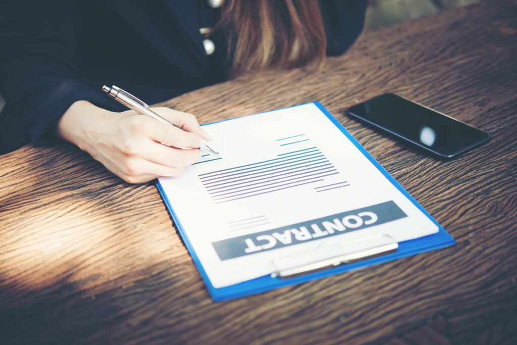 happy business woman signing on document in a desk working at ho